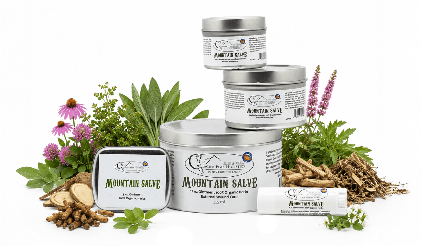 Mountain Salve organic pet ointment tins and balm stick surrounded by fresh herbs and roots on a white background.