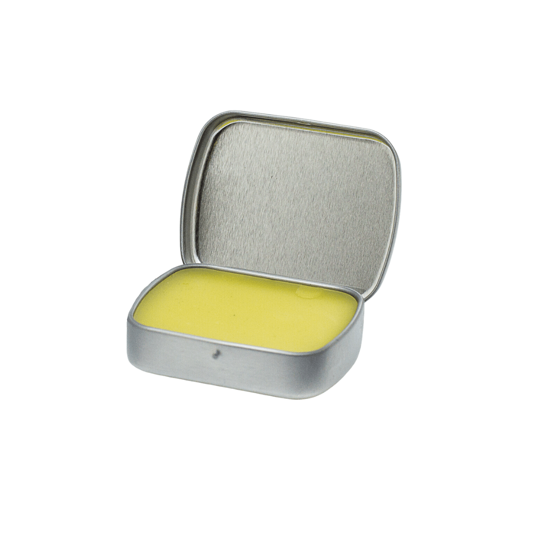 An open tin of Glacier Peak Holistics Mountain Salve For All Pets reveals the yellow ointment inside.